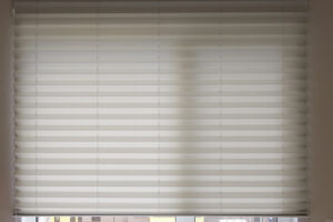 Pleated shades size XL, Coulisse, 50mm fold, close up on the window, white color, white background. Modern pleated blinds, luxury sun protection and window decoration.